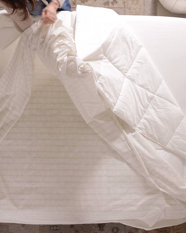 image of woman putting on a duvet cover